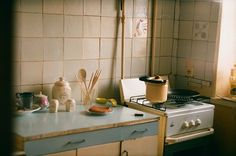 a stove top oven sitting inside of a kitchen next to a counter with utensils on it