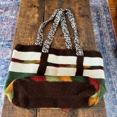 a brown and white bag sitting on top of a wooden table next to a rug