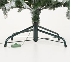 a christmas tree with a green phone on it's stand next to a white background