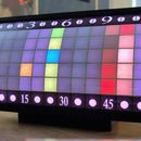 a computer screen displaying an array of colors on it's display surface in front of a window