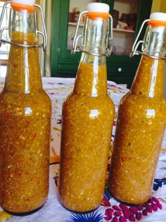 three bottles filled with mustard sitting on top of a table