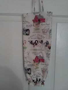 an oven mitt hanging on a door handle with farm animals and words all over it