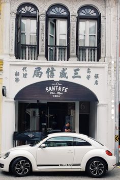 a white car parked in front of a building