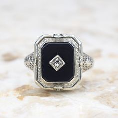 Antique 14k white gold Art Deco era flip ring. One side has a carved shell cameo. The other, an onyx stone set with a small diamond. The filigree setting has blossom details on the shoulders and along the band.  Era: Art Deco c.1920 Markings: 14k PATENTED  Materials: 14k white gold, shell, onyx, diamond  Ring Size: 6.5 (Comes with one free resizing by our jeweler) Weight: 3.1 grams Face measures 14mm x 12mm Condition: Excellent antique condition with minor wear from age  Shipping is free in the United States  Follow us on Instagram @LUXXORVintage Classic White Gold Rings With Black Enamel, Classic Formal Enamel Ring, Classic Formal Enamel Diamond Ring, Formal White Gold Ring With Black Enamel, Elegant Formal Intaglio Signet Ring, Classic White Gold Onyx Rings, Formal White Gold Enamel Ring With Black Detail, Formal White Gold Enamel Ring With Diamond Accents, Formal Silver Ring With Black Enamel