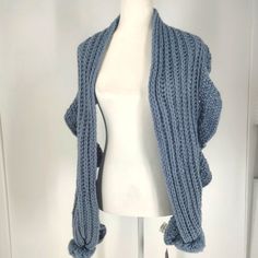 a white mannequin wearing a blue knitted cardigan