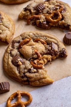 chocolate chip cookies with pretzels and nuts on parchment paper, ready to be eaten