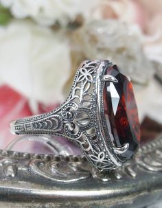 Red Garnet Ring Description Persian Design#230 MADE TO ORDER This is a brand new stunning Art Nouveau/Vintage designed sterling silver filigree 9ct oval red garnet CZ ring. The Flawless oval full cut high-quality garnet CZ is 18mm (just shy of 3/4th of an inch) by 13mm (1/2 inch) in dimension... This ring is 21mm NS on the finger. The inside of the band is marked 925 for sterling. Notice the beautiful filigree swirl like the craftsmanship of the silver setting. This lovely ring stands out and il Oval Ruby Ring With Intricate Design, Classic Oval Ruby Ring, Antique Oval Filigree Ring Gift, Ornate Garnet Round Rings, Vintage Garnet Ring With Center Stone, Ornate Round Garnet Rings, Victorian Red Oval Filigree Ring, Vintage Garnet Ruby Ring With Intricate Design, Collectible Oval Ruby Ring In Silver