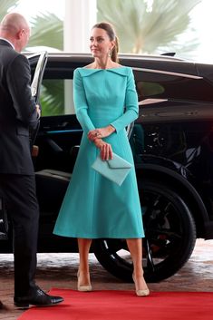 a woman in a blue dress standing next to a man