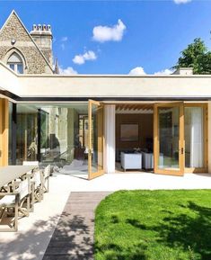 an outdoor dining area with sliding glass doors and wooden furniture on the outside patio, surrounded by lush green grass