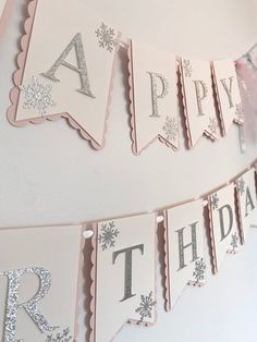 a happy birthday banner hanging on the wall with glitter letters and snowflakes around it