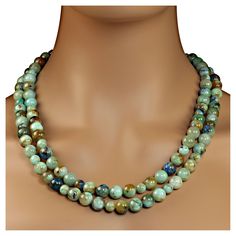 Gloriously green Chrysocolla and lots of other colors in this double strand 22 inch. Green enhances everything. Wear this gorgeous necklace with all your winter wardrobe. The 10mm and 8mm beads feature shades of green, blue, brown, tan, and cream. A gold-plated easy to use toggle clasp secures the necklace. MN 2332 Luxury Double Strand Gemstone Beaded Necklaces, Luxury Double Strand Beaded Chain Necklace, Luxury Green Turquoise Necklace With Polished Beads, Luxury Green Turquoise Necklace With Large Beads, Cheap Green Double Strand Beaded Necklace, Affordable Green Double Strand Beaded Necklaces, 8mm Beads, Double Strand Necklace, Green Necklace