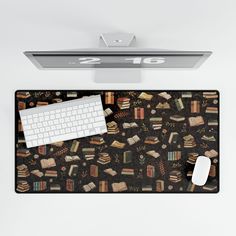 a computer keyboard and mouse sitting on top of a mouse pad with books all over it