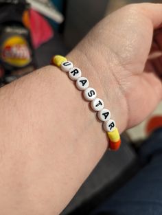 a person wearing a bracelet with letters on it