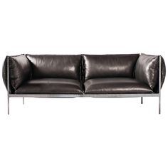 a black leather couch sitting on top of a white floor