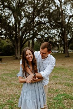 a man and woman are holding each other in the grass