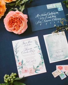 the wedding stationery is laid out with flowers