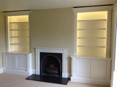 empty living room with fireplace and built - in bookcases