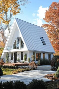 a white house with a metal roof in the fall