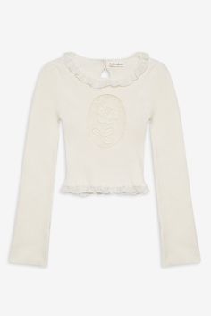 Inspired by vintage motifs, the Lyon white knit top shows off an inset rose cameo at the bust. This slightly cropped sweater is crafted in a ribbed knit and features a high neck with a lace ruffled trim. Cream Knitted Tops, White Coquette Sweater, Vintage Motifs, White Knit Top, Perfect White Tee, Trim Fit, Solid & Striped, Little White Dresses, Lace Ruffle