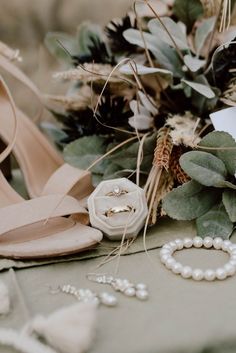 the wedding bouquet and shoes are on the table