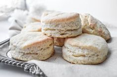 biscuits are stacked on top of each other on a silver plate with a white cloth