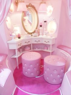 a pink room with vanity, stools and mirror