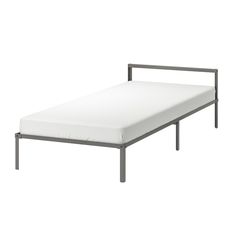 a metal bed frame with white sheets on it