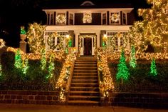 a house with christmas lights on the front and stairs leading up to it's entrance