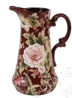 a brown and pink flowered pitcher with handles