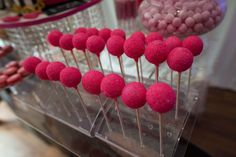 there are many pink candies on the stick in the display case at the candy store