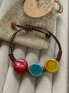 Beautiful, colourful, ceramic beaded bracelet, beaded on a brown cord Adjustable cord  to 16cm Comes in a little drawstring bag Ceramic Bracelet, Ceramic Jewellery, Bracelet Beaded, Ceramic Jewelry, Ceramic Beads, Adjustable Bracelet, Drawstring Bag, Beaded Bracelet, Favorite Jewelry