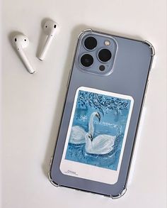 an iphone case sitting on top of a table next to ear buds