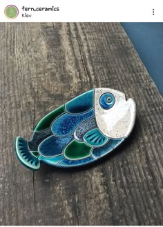 a fish shaped dish sitting on top of a wooden table