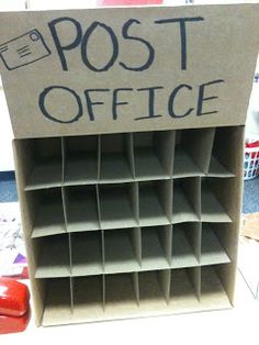 a cardboard post office sign sitting on top of a desk