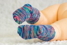 a doll's feet with colorful socks laying on top of it