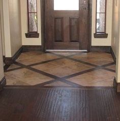 an empty entryway with wooden doors and tile flooring in front of the door