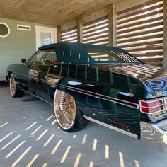 a black car parked in front of a garage