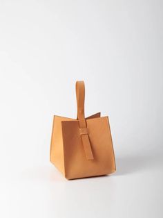 The Cube handbag is a pleasure to carry in your hand or on your wrist. The structural, unique cube shape offers spacious storage and boasts a hidden magnetic closure embedded in its handle. The 100% Veg-tanned Vachetta leather bag is intentionally unlined. Studio Bag, Cube Shape, Platform Flats, Rose Lily, Crafts Workshop, Scarf Jewelry, Leather Care, Diy Bag, Magnetic Closure