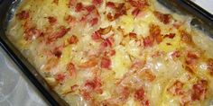 a casserole dish with cheese and bacon on it sitting on a white table cloth