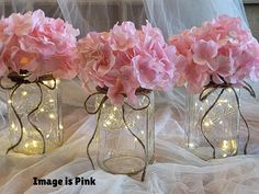 pink flowers in mason jars with fairy lights