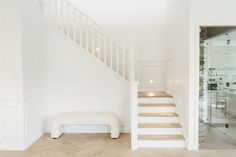 a white room with stairs and a bench