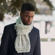 a man in a suit and scarf walking down the street