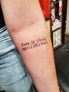 a person with a tattoo on their arm that reads june 16, 1911 and is written in black ink