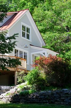 a large white house surrounded by trees and rocks