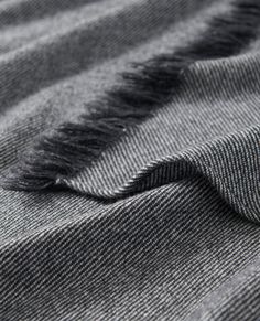 the texture of a gray and black striped fabric with fringes on it's edges