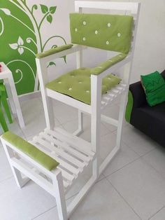 a white chair with green cushions in a room