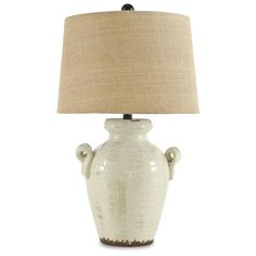 a white vase lamp with a beige shade