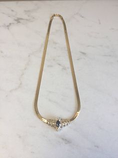 "An incredible 14kt Yellow Gold Lady's Diamond and Sapphire Necklace in 16\" consisting of 1- 8mm x 4m .75ct approx. total weight Genuine Marquise Sapphire with .50ct total weight of diamonds SI1/SI2 clarity, G color prong and channel set surrounding the gemstone with a flat 4mm Herringbone style chain with a heavy box clasp. This show stopper will lighten up any evening when worn. Sapphire is the Birthstone for September. The total weight of this Necklace is 14.5 grams. This item would Retail f Elegant Polished Snake Chain Necklace, Elegant Snake Chain Necklace With Polished Finish, Timeless Marquise Gold Necklace, Timeless Gold Marquise Necklace, Timeless Gold Necklace With Marquise Shape, Elegant Formal Necklace With Snake Chain, Elegant Snake Chain Jewelry For Formal Occasions, Elegant Snake Chain Necklace For Formal Occasions, Elegant Formal Snake Chain Necklace