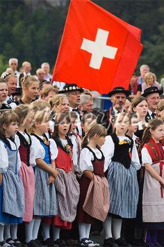 a group of children standing next to each other in front of a flag