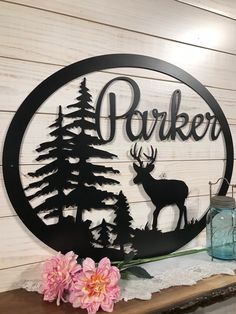 a metal sign that says parker with deer and pine trees